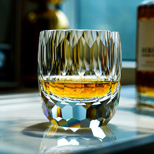 Edo Kiriko inspired diamond-cut crystal glass filled with amber whisky resting on a reflective surface, showcasing 64 light-refracting facets.