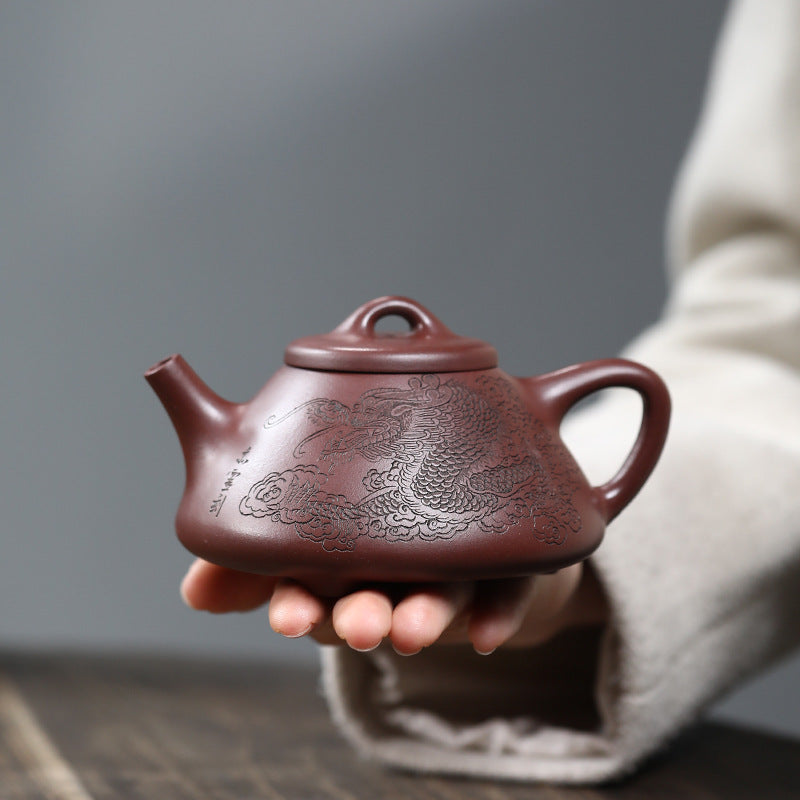 A hand holding the 250ml Rich Dragon Pan Pot (富贵龙潘壶) to show the intricate dragon pattern. This fully handmade Yixing Zisha teapot by artist Fan Qinjun (范勤君) is sourced directly from Yixing. Founded and operated by a U.S. Ph.D. graduate, JiangnanSourcing.com is dedicated to providing high-quality, authentic teaware.